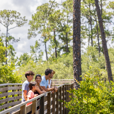 Family enjoying a walk down a trail in the Gulf State Park on Alabama's Beaches