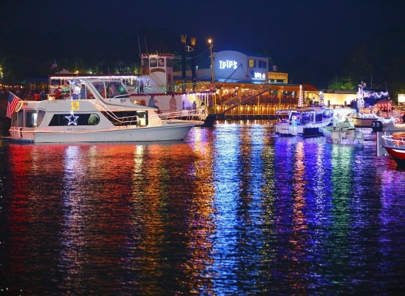 Illuminated boats floating along the Intracoastal Waterway for the Annual Lighted Boat Parade Christmas event on Alabama's Beaches