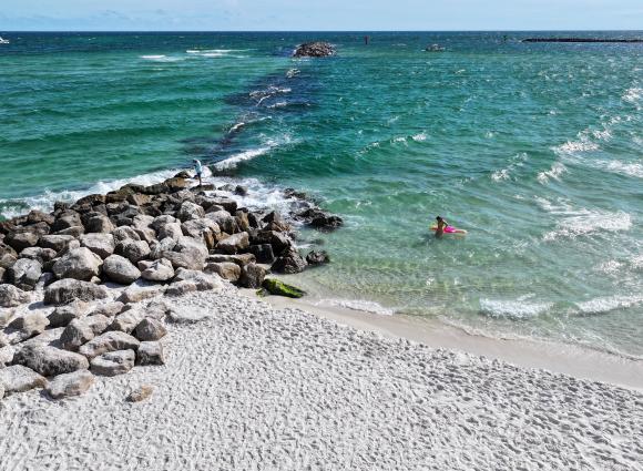 Aerial view of the jetties in Orange Beach, Alabama with clear, blue water