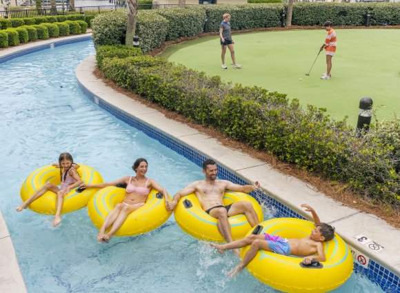 Family floating on a lazy river at their condo rental on Alabama's Beaches