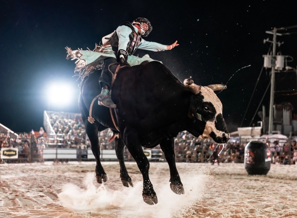 Cowboy riding a bull at Flora-Bama's Bulls on the Beach rodeo in Orange Beach