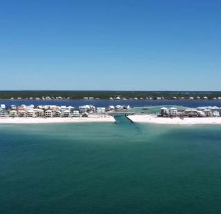 Scenic view of Little Lagoon in Gulf Shores, Alabama, featuring beach houses along the shoreline and clear turquoise waters