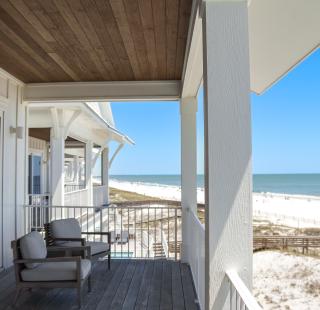 Relaxing beachfront view from a vacation rental balcony overlooking the white sand shores of Alabama’s Beaches