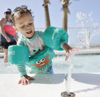 Kid enjoying the splash pad at their hotel