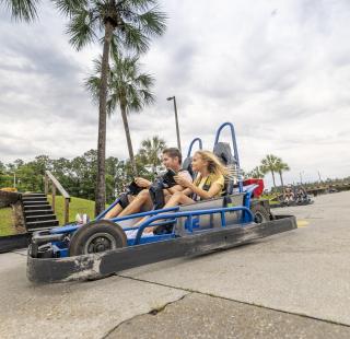 Dad and daughter racing go-karts at The Track Family Fun Park