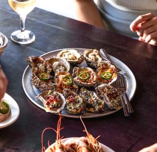 Plate of chargrilled oysters at The Gulf Shores steamer seafood restaurant in Gulf Shores