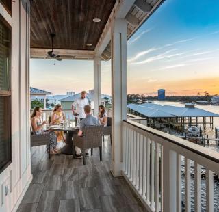 Family dining on the balcony of a beach house rental in Orange Beach