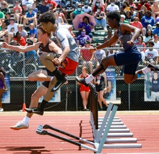 Track athletes jumping hurdles during the AHSSA Championship on Alabama's Beaches