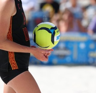 NCAA Beach Volleyball player getting ready to serve