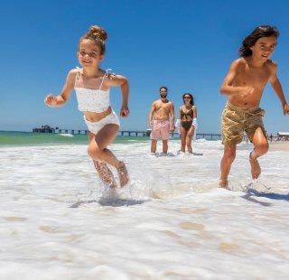 Family on the beach enjoying their summer getaway on Alabama's Beaches