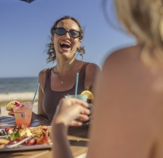 Friends enjoying food while watching the game during fall on Alabama's Beaches