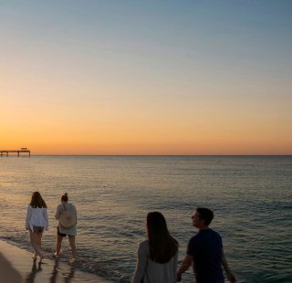 Family walking along the beach at sunset in Gulf Shores