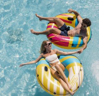 A couple enjoying their pool at their vacation rental on Alabama's Beaches