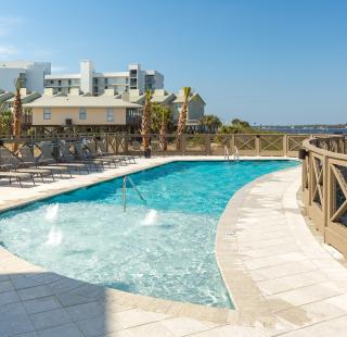 Outdoor pool area with lounge chairs at a vacation rental in Gulf Shores, Alabama