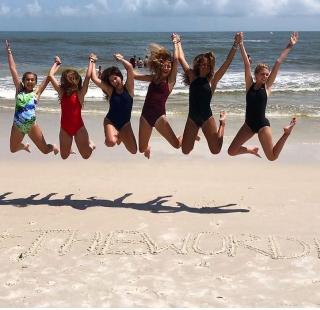 Girlfriends jumping at the beach