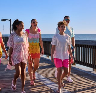 Family walking along the Gulf State Park Pier, sightseeing attraction in Gulf Shores