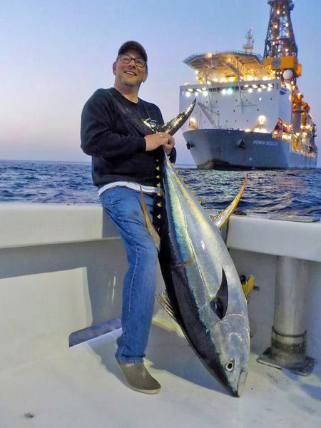 Fisherman holding yellowfin tuna in Gulf of Mexico