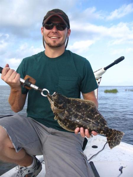 Fisherman holding flounder