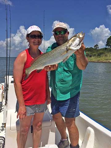 Couple holds catch while Coastal fishing in Alabama